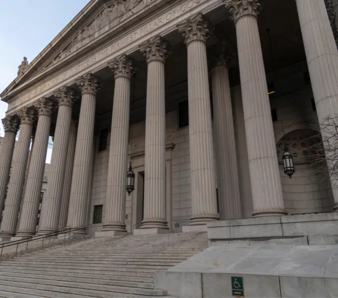Neoclassical government building featuring tall stone columns and a wide staircase