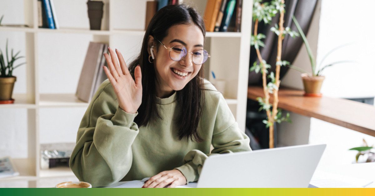 girl-waving-at-laptop-in-college-library